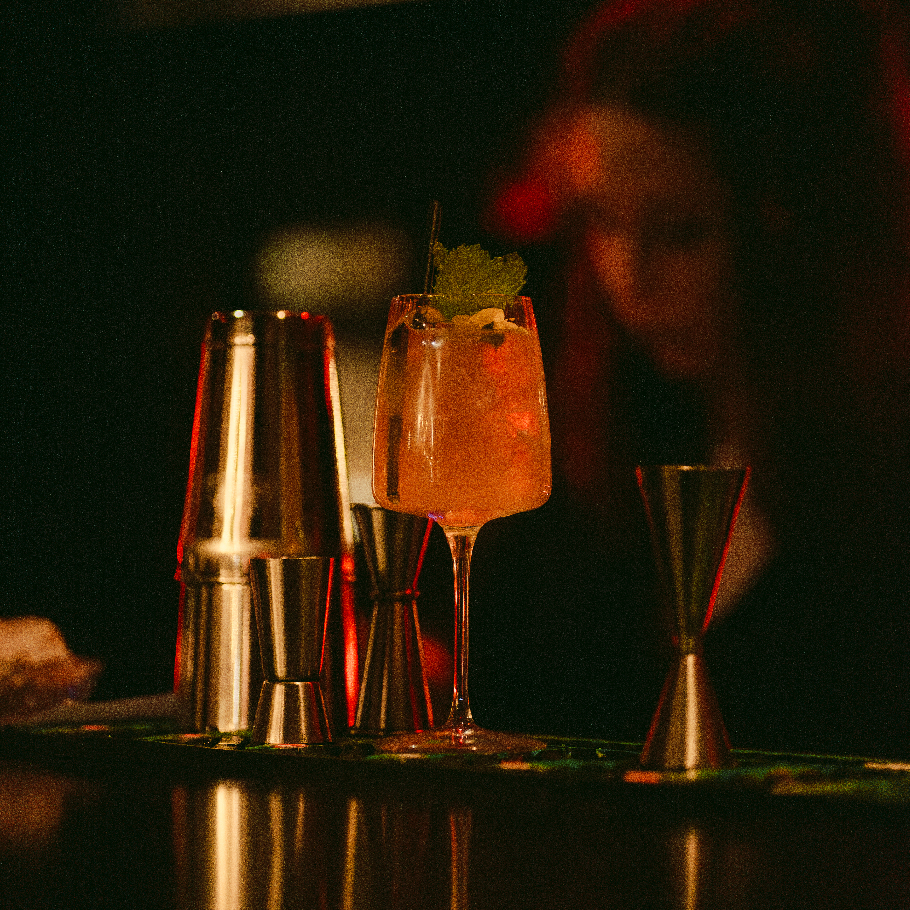 cokctails comptoir carre Un cocktail posé sur une table du bluebird cocktail bar à chambéry avec un téléphone en arrière plan et des oiseaux